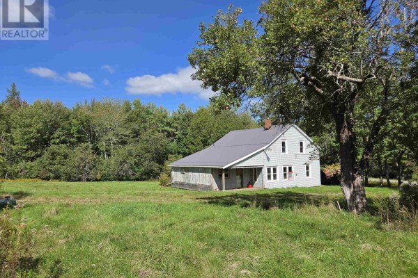 Rear view of a light blue house with a metal roof and attached garage in a grassy yard. - 415 Old Harmony Road, Harmony Mills