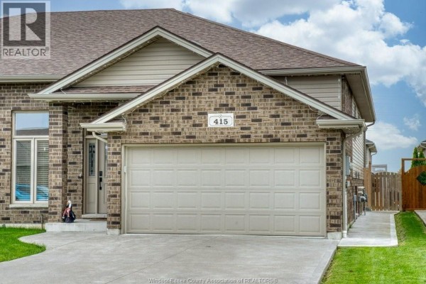 Front exterior view of 415 Rosewood Drive with beige garage door and brick exterior. - 415 Rosewood Drive, Lakeshore