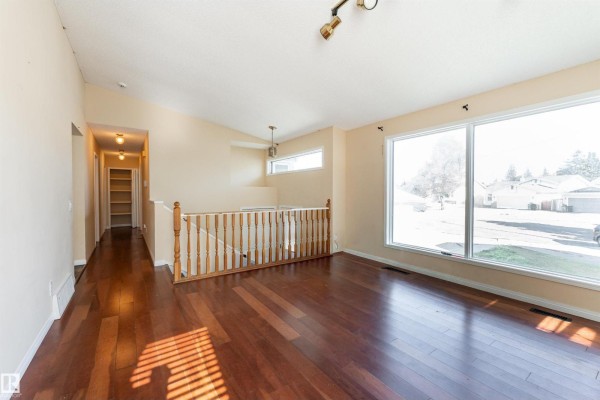 Living room with hardwood floors, large windows, and a view of the street. - 4151 28 Av Nw, Edmonton