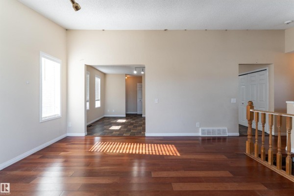 Spacious living room with hardwood floors and windows overlooking the neighbourhood. - 4151 28 Av Nw, Edmonton