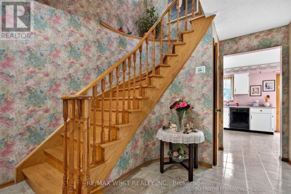 Living room with parquet floors, pink walls, and view into kitchen. - 4157 Ottewell Crescent, Mississauga