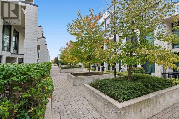 Courtyard walkway with paved stone, planters, and trees. - 416 - 130 Widdicombe Hill Boulevard, Toronto