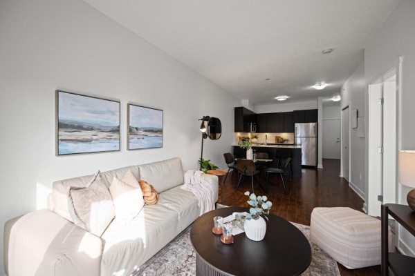 Apartment hallway with wood floors, round mirror, and doorway leading to the living area. - 416 20460 Douglas Crescent, Langley