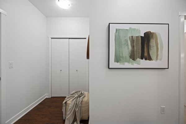 View of a bathroom with toilet, vanity, and shower; next to hallway with art. - 416 20460 Douglas Crescent, Langley