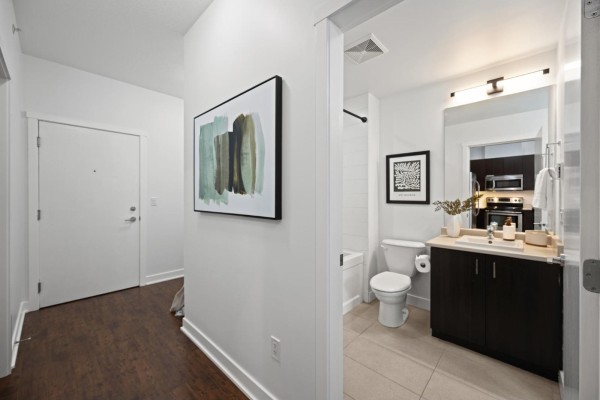 Small office room with desk, chair, artwork, and yoga mats in a basket. - 416 20460 Douglas Crescent, Langley