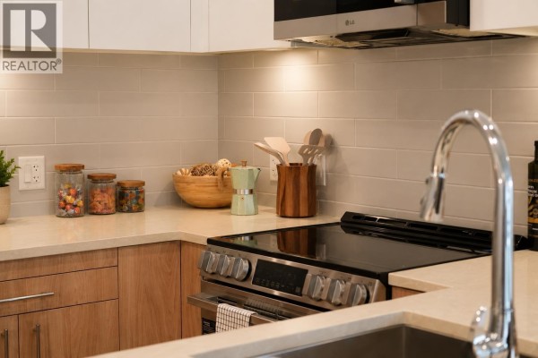 Close-up of a kitchen counter with a stovetop, backsplash tiles, and sink. - 416 245 Bewicke Avenue, North Vancouver