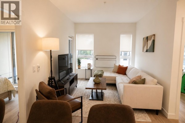 Open concept living space with sofa, chairs, coffee table, and television. - 416 245 Bewicke Avenue, North Vancouver
