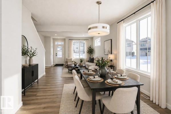 Dining area with dark wood table, beige chairs, and view into living room. - 416 26 St Sw, Edmonton