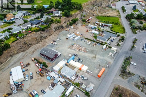 Overhead view of the commercial site including buildings, storage units, construction materials, and vehicles. - 416 Hollis Road, Ashcroft