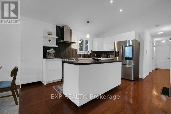 Basement living area featuring a stone fireplace, laminate flooring, and double closets. - 4165 Lloydtown-aurora Road, King