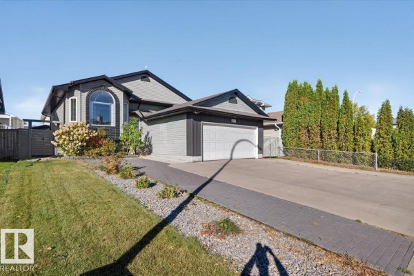 Right side exterior view of a grey house with a white garage door and manicured landscaping. - 417 Hollick Kenyon Rd Nw Nw, Edmonton