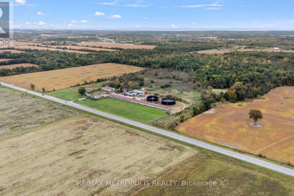 Aerial view of a farm property with fields, buildings, and silos next to a road. - 4175 Netherby Road, Fort Erie