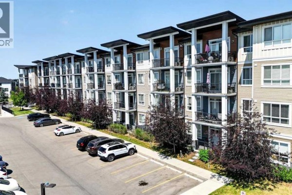 Exterior view of modern apartment building with balconies and parking lot. - 418, 10 Walgrove Walk Se, Calgary