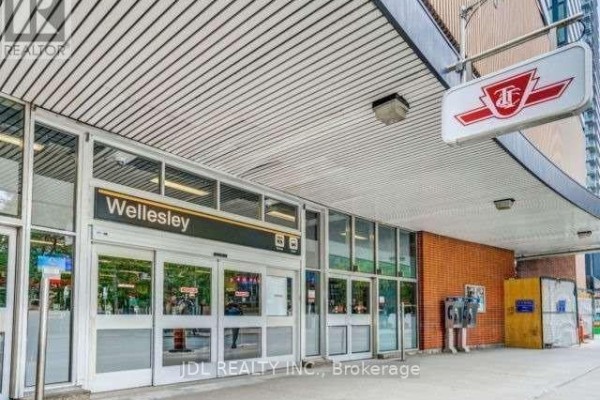 Exterior shot of the Wellesley subway station entrance with glass doors and brick accents. - 418 - 11 St Joseph Street, Toronto