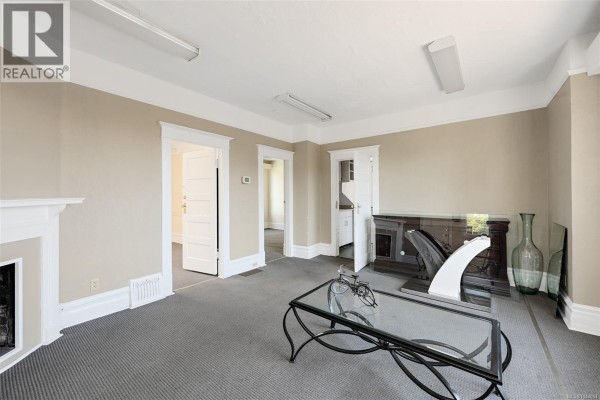 Another angle of the dining area with a TV, fireplace, and access to adjacent rooms. - 418 Alpha Terr, Victoria
