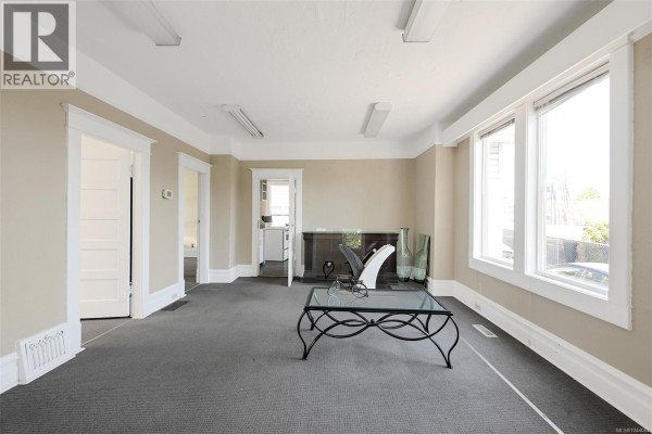Kitchen space with white appliances, overhead shelving, and a laundry area. - 418 Alpha Terr, Victoria