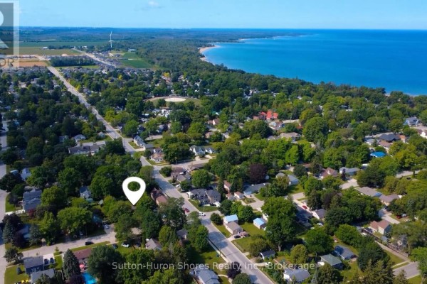 Side view of the house showing mature trees and shrubs on the property. - 418 Elgin Street, Saugeen Shores