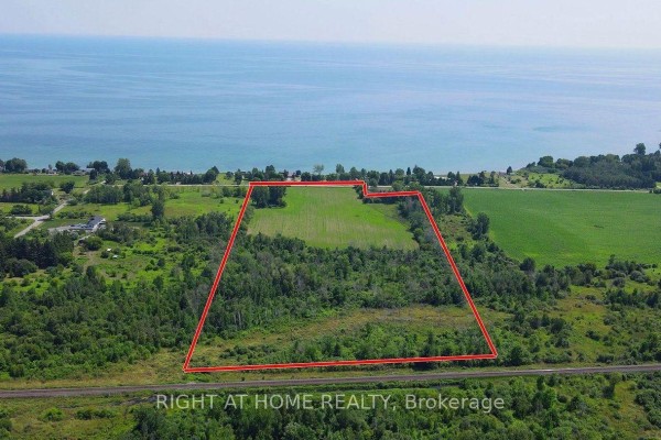 Aerial view of a large property outlined in red, with fields and trees near the water. - 418 Victoria Beach Road, Cramahe