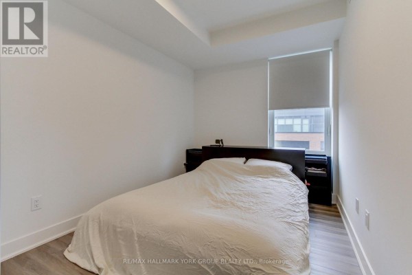 Bedroom with a queen-size bed, dark wood headboard, nightstands, and a window with blinds. - 419 - 185 Deerfield Road, Newmarket