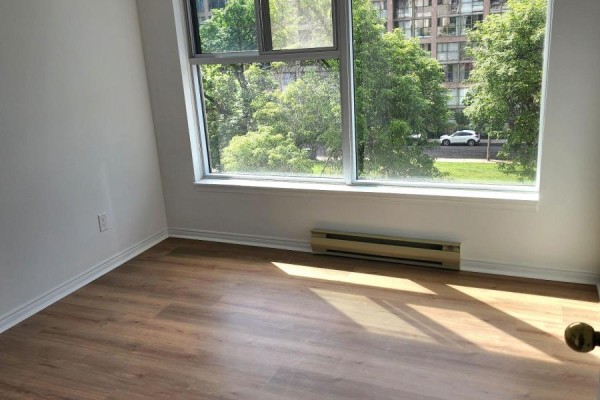 Bedroom with light wood laminate flooring and a large window with trees. - 419 - 222 The Esplanade, Toronto