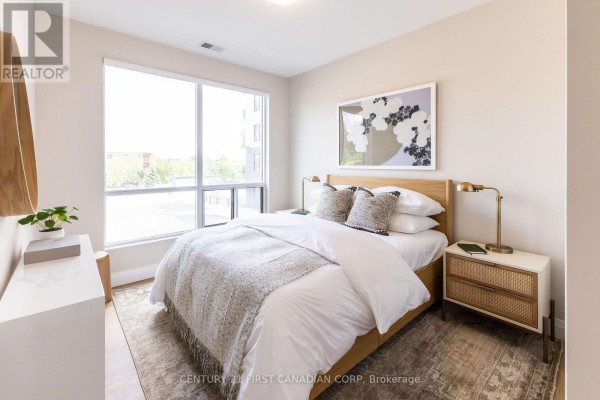 Bedroom with a queen-sized bed, large window, and modern nightstands with brass lamps. - 419 - 230 North Centre Road, London North