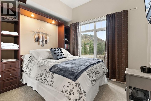 Front view of the apartment building featuring stone and wood accents - 419 1395 Bear Mountain Pkwy, Langford
