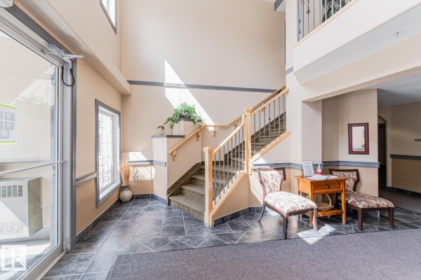 Interior view of a dining area with a table, chairs, and a mirrored closet door. - #419 261 Youville Dr Nw, Edmonton