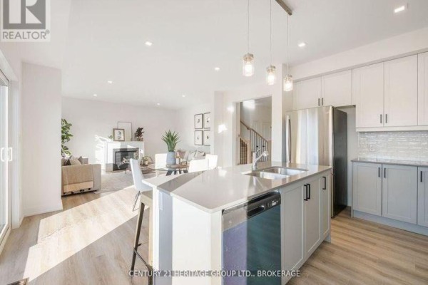 Kitchen with white and grey cabinets, stainless steel appliances, a large island, and a view of the living room. - 42(lot 20) Dusenbury Drive, Loyalist