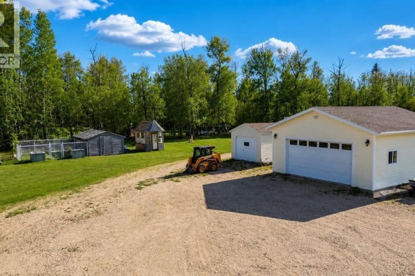 Outbuildings including a garage, shed, and enclosures on a gravel driveway. - 42, 113033 Township Road 592, Rural Woodlands County