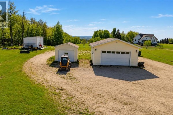 Aerial view of outbuildings and a distant house on a large rural property. - 42, 113033 Township Road 592, Rural Woodlands County