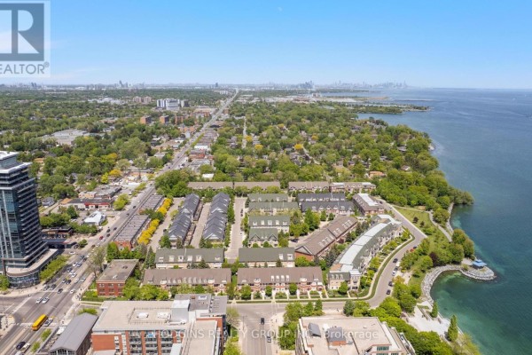 Open-concept living area with a kitchen island, dining table, and leather chairs. - 42 - 136 St Lawrence Drive, Mississauga