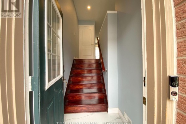 View from inside a townhouse looking up a staircase with dark wood steps and light blue walls. - 42 - 3020 Cedarglen Gate, Mississauga