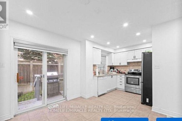 View of the kitchen with white cabinets and stainless steel appliances, and a patio door. - 42 - 435 Middlefield Road, Toronto