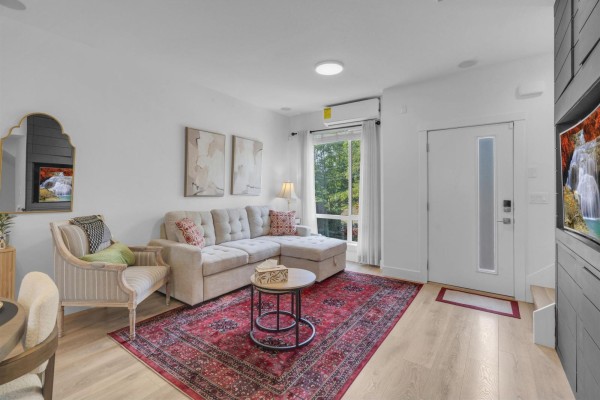 Living room with sectional sofa, patterned rug, and armchair. - 42 16433 19 Avenue, White Rock