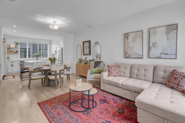 Living room with sectional sofa, dining area, and kitchen in background. - 42 16433 19 Avenue, White Rock