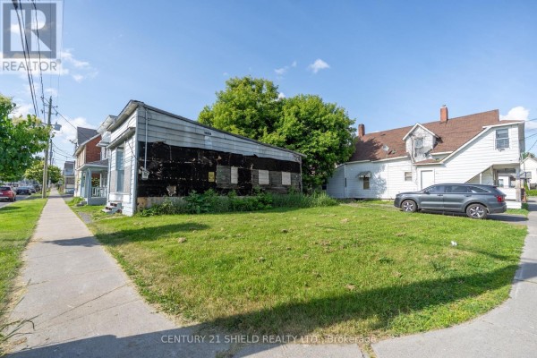 View of properties on Marlborough Street South, Cornwall, showing a sidewalk, grass lawn, and parked car. - 42-46 Marlborough Street S, Cornwall