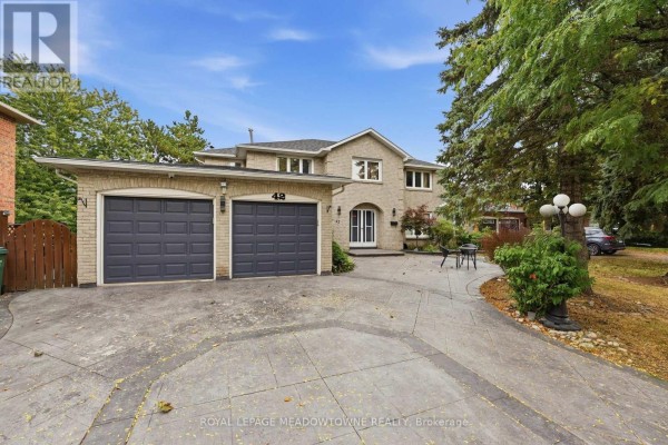 Front exterior of house with double garage doors and driveway. - 42 Dawnridge Trail, Brampton