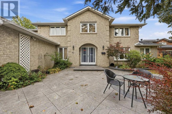 Front entrance of brick house with double doors and paved patio. - 42 Dawnridge Trail, Brampton