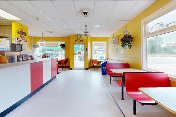 Interior dining area with yellow walls, red booths, and tables. - 42 Main Street, Winnipeg Beach