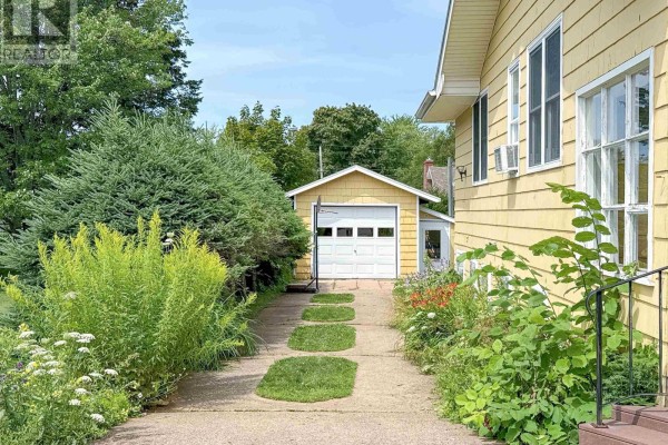 Driveway leading to a detached single-car garage with a white overhead door. - 42 Roper Drive, Sherwood