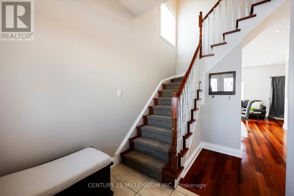 Staircase view with hardwood flooring and natural light from windows. - 42 Rubysilver Drive, Brampton