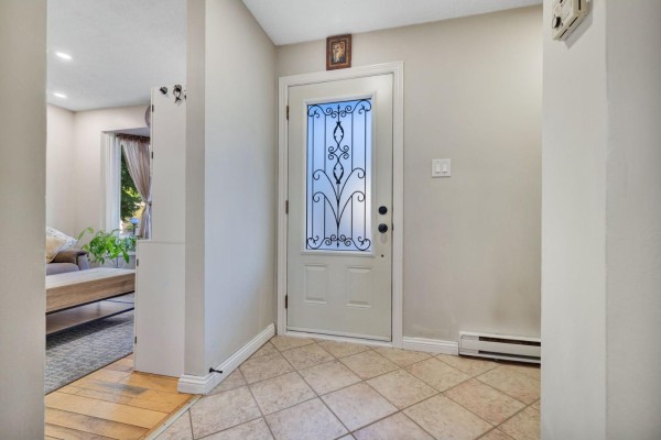 View of a beige entryway with a decorative glass door, tiled floor, and access to a living area. - 42 Rue De Loranger, Gatineau