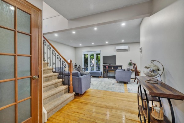 Interior view of a home with hardwood floors, a carpeted staircase, and a living room area. - 42 Rue De Loranger, Gatineau