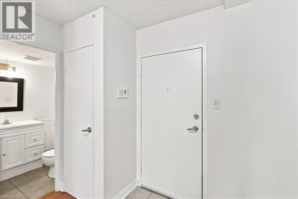 Interior hallway with doors to bathroom and front entrance. - 42 Tannery Street E Unit# 246, Cambridge