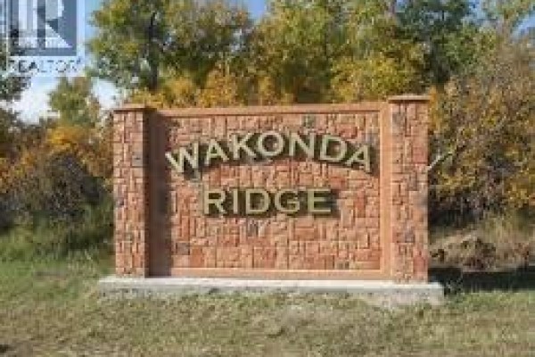 Stone monument sign with "WAKONDA RIDGE" carved into it, surrounded by grass and trees. - 42 Wakonda Drive, Hoodoo Rm No  401