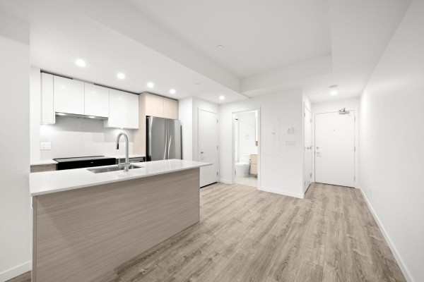 Interior apartment view showing kitchen, island, and entrance to a bathroom. - 420 10828 139a Street, Surrey