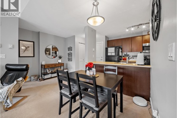Dining area with a table and chairs next to a kitchen counter. - 420 12238 224 Street, Maple Ridge