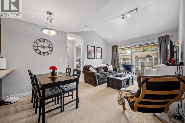 Combined living and dining area with a sofa, table, and fireplace. - 420 12238 224 Street, Maple Ridge