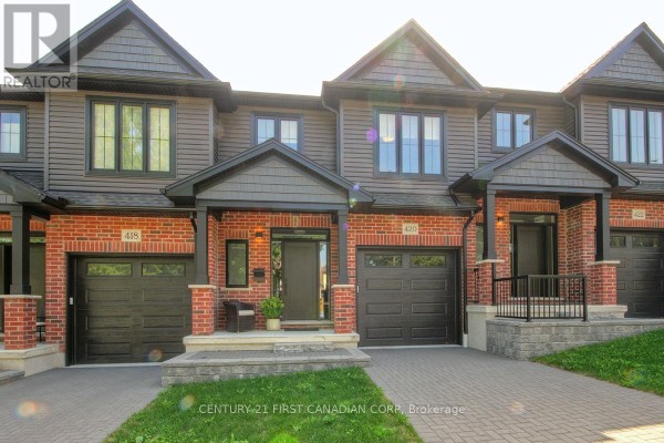 Front view of attached townhouses with brick and siding exteriors, and garages. - 420 Old Wonderland Road, London South