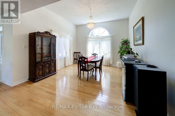 View from the top of stairs looking down at foyer, double doors, and living/dining area. - 420 Ramblewood Drive, Wasaga Beach